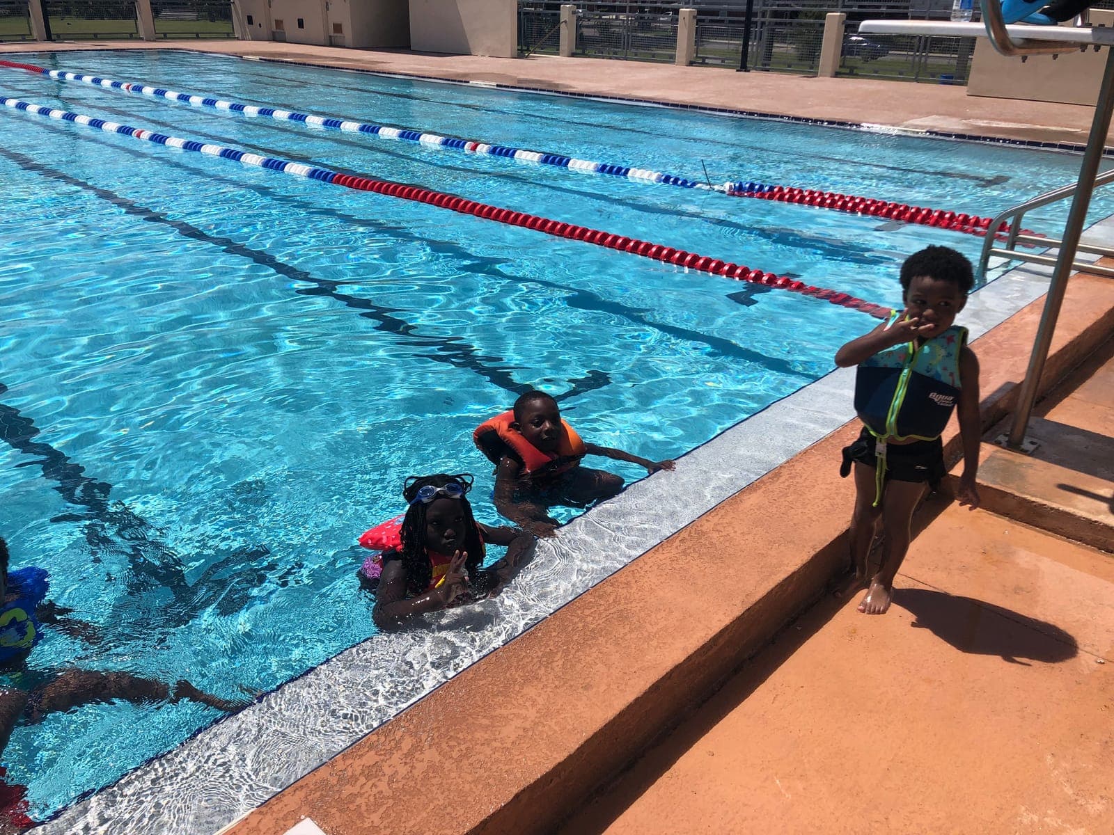 Children in life jackets smiling in the pool